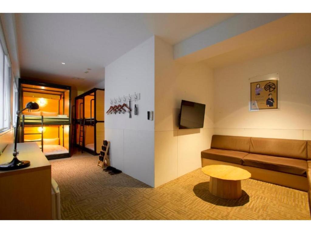 ein Wohnzimmer mit einem Sofa und einem Tisch in der Unterkunft Kamon Hotel Namba - Vacation STAY 37041v in Osaka