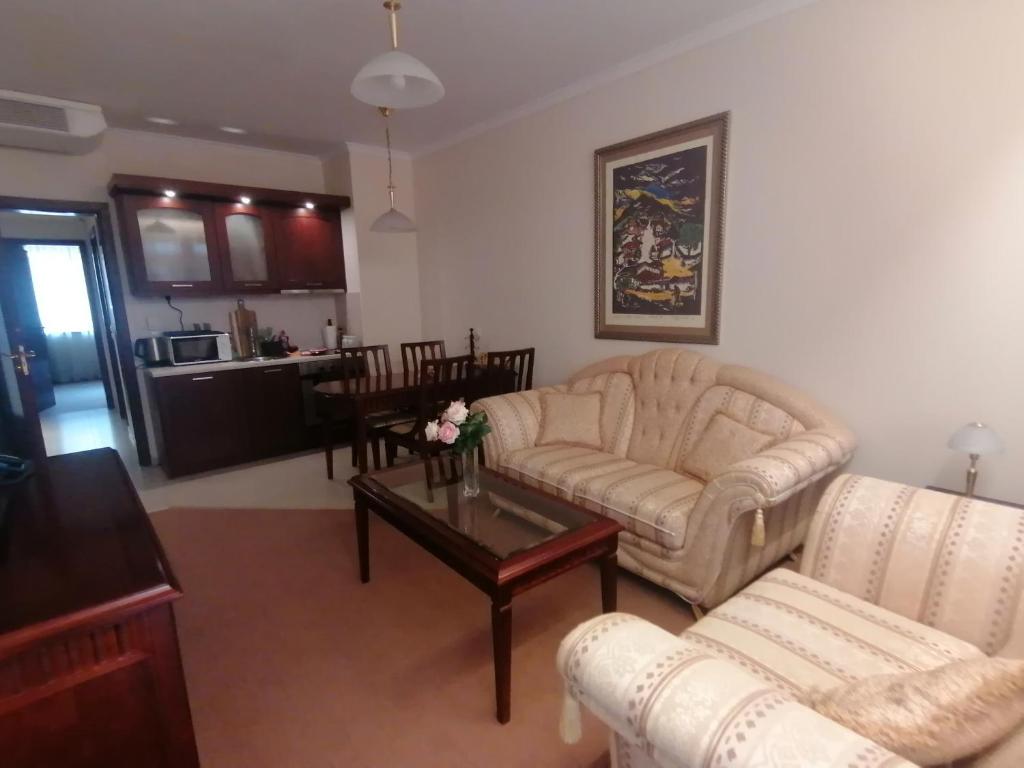 sala de estar con sofá y mesa en Апартамент за гости Мая Downtawn Банско, en Bansko