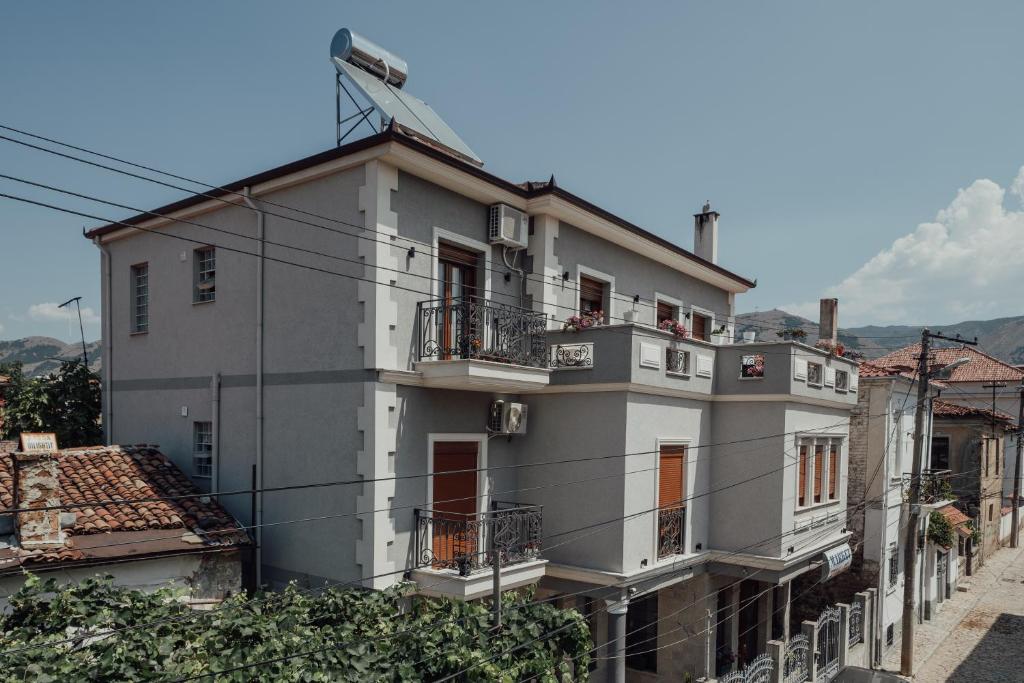 un gran edificio blanco con balcones en una calle en Guesthouse Sara & Esi, en Korçë