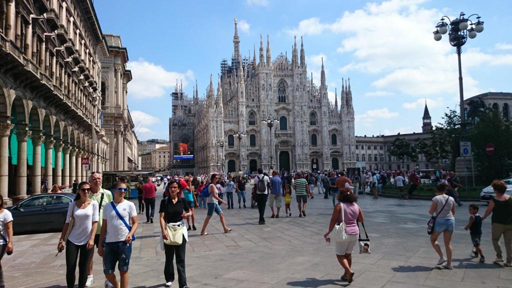 um grupo de pessoas andando em frente a uma catedral em Flat in Duomo em Milão