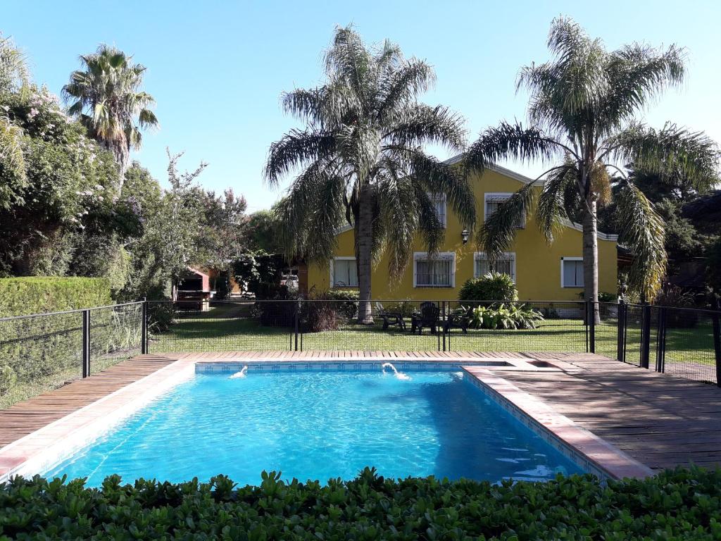 una piscina frente a una casa con palmeras en Morada del Arroyo en Colón