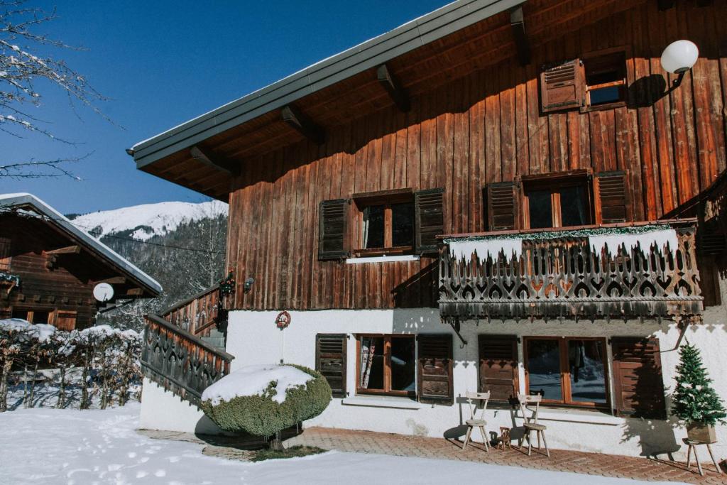 un grand bâtiment en bois avec un balcon dans la neige dans l'établissement Les Chalets de Jean Jeanne - Chalet La Bornette, à Morzine