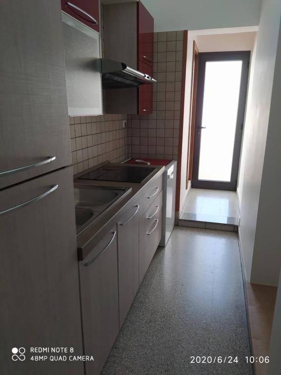 kuchnia z urządzeniami ze stali nierdzewnej i oknem w obiekcie A due passi dal mare w mieście Otranto