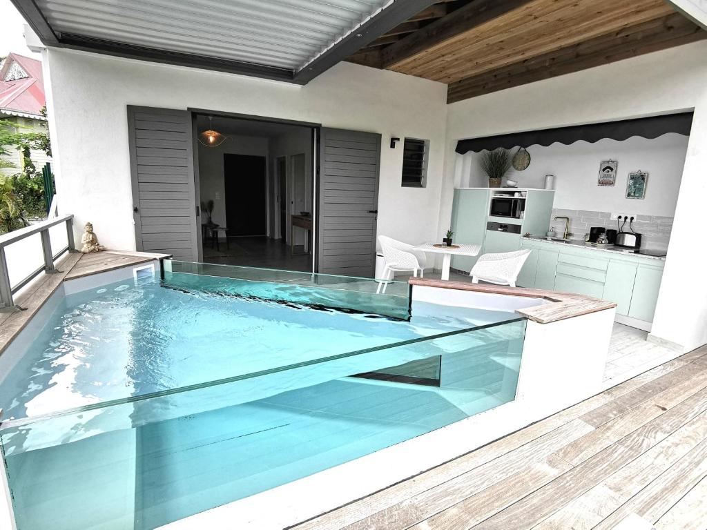 uma piscina num pátio com uma casa em Habitation I'SEO Adult Only em Sainte-Anne