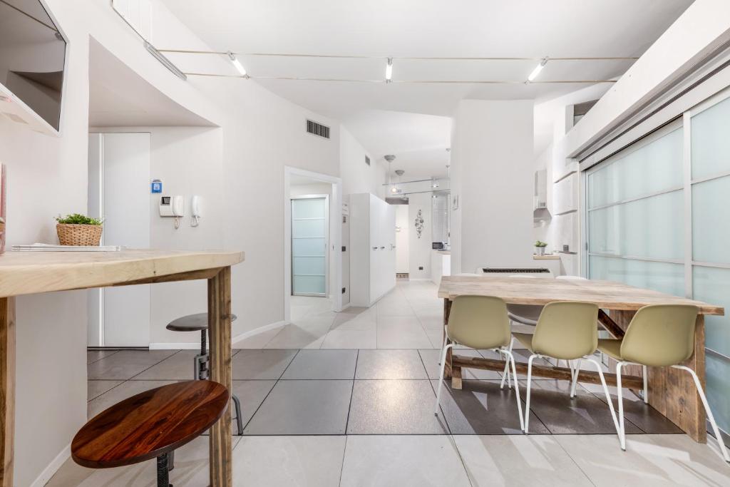 een keuken met witte muren en een houten tafel en stoelen bij Casa da Suite Splendida in Milaan