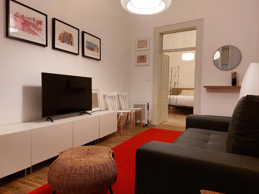 a living room with a flat screen tv and a couch at Estúdio na Carreira in Elvas