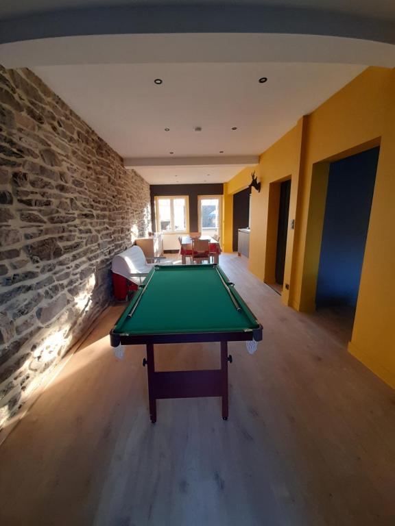 una mesa de ping pong en una habitación con una pared de piedra en Maison de vacances familiale à Vresse s/ Semois en Vresse-sur-Semois