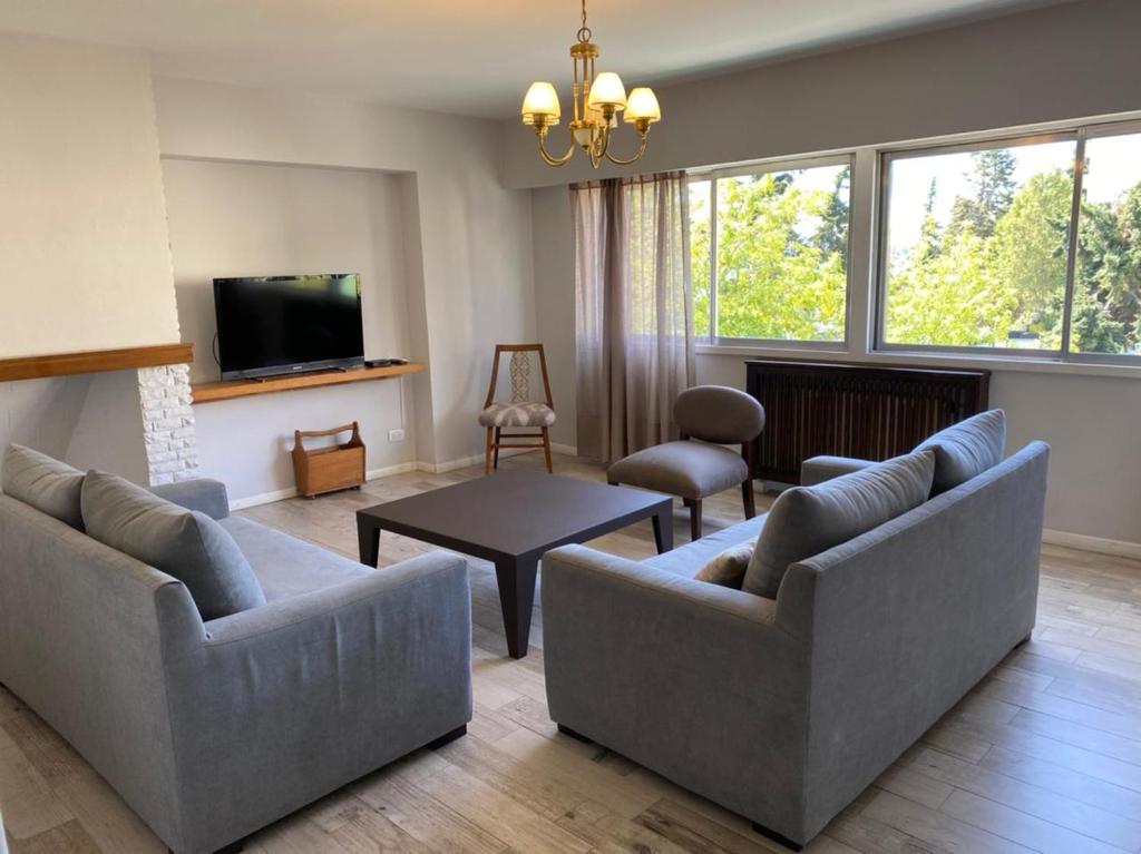 a living room with two couches and a tv at Departamento Costanera in San Carlos de Bariloche