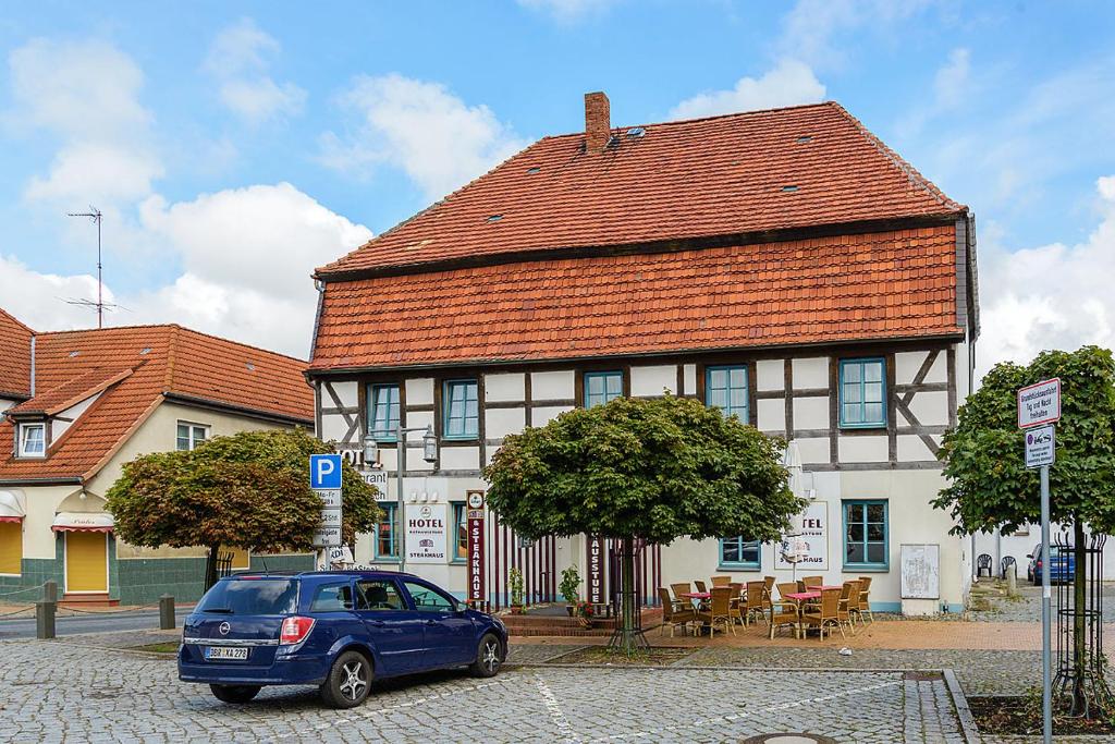 a blue car parked in front of a building at Ostseehotel Neubukow in Neubukow
