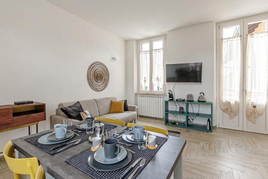 salon ze stołem i kanapą w obiekcie Al 33 di Via Roma - Apartments w mieście Cardano al Campo