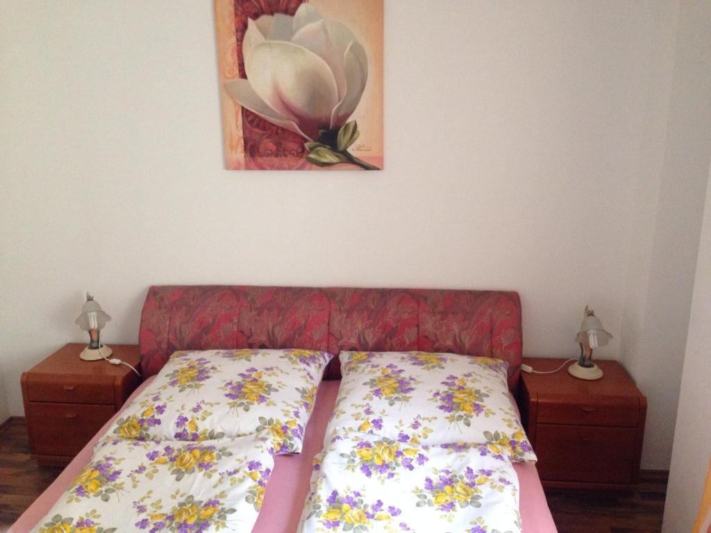 a bed in a room with two night stands and a painting at City Apartment in Nürnberg Center in Nuremberg