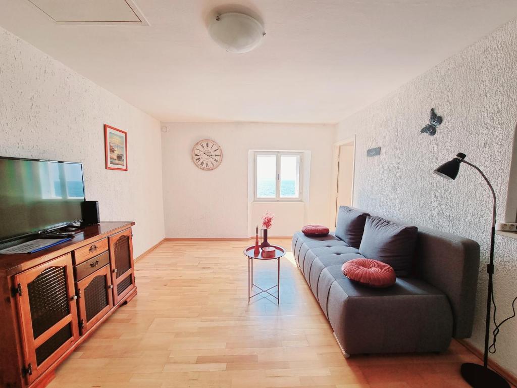 a living room with a couch and a flat screen tv at Sea View Apartments Piran in Piran