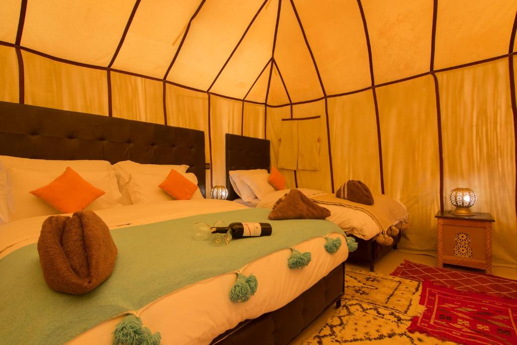 a bedroom with two beds in a tent at Sunset luxury camp in Hassilabied