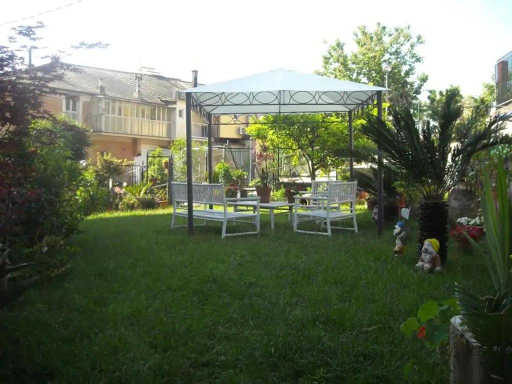 a garden with a table and chairs in the grass at Appartamenti da Ermanno in Bonassola