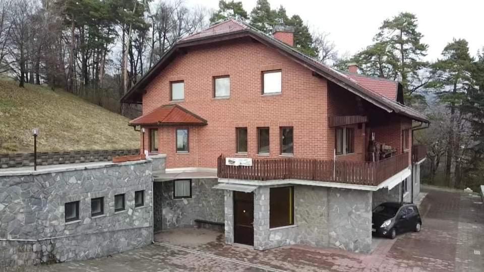 een groot bakstenen huis met een stenen muur bij Kegljišče VISOLE Apartmaji in Sobe in Slovenska Bistrica