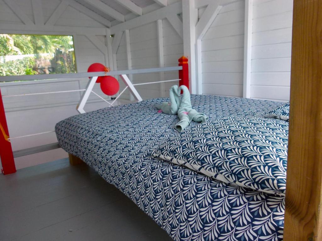 un dormitorio con una cama con un animal de peluche en Ti Mango Fil en Le Gosier