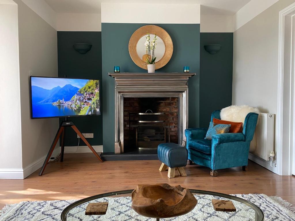 a living room with a fireplace and a tv at Llandudno Boutique style seaside retreat with stunning views in Llandrillo-yn-Rhôs
