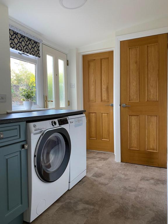 a laundry room with a washing machine and a window at Llandudno Boutique style seaside retreat with stunning views in Llandrillo-yn-Rhôs