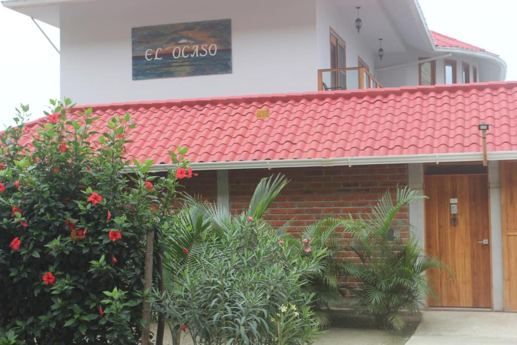 ein Gebäude mit rotem Dach und einigen Pflanzen in der Unterkunft El Ocaso in Canoa