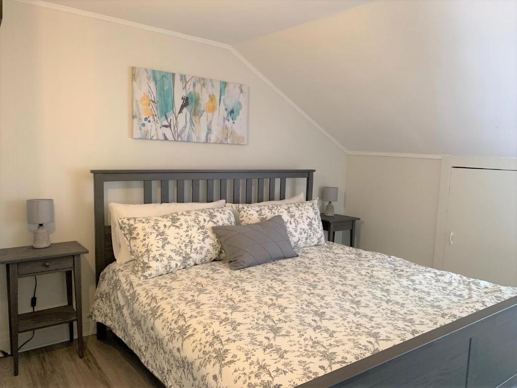 una camera da letto con un letto e un piumone a fiori di County Cove - Bloomfield Suite a Wellington