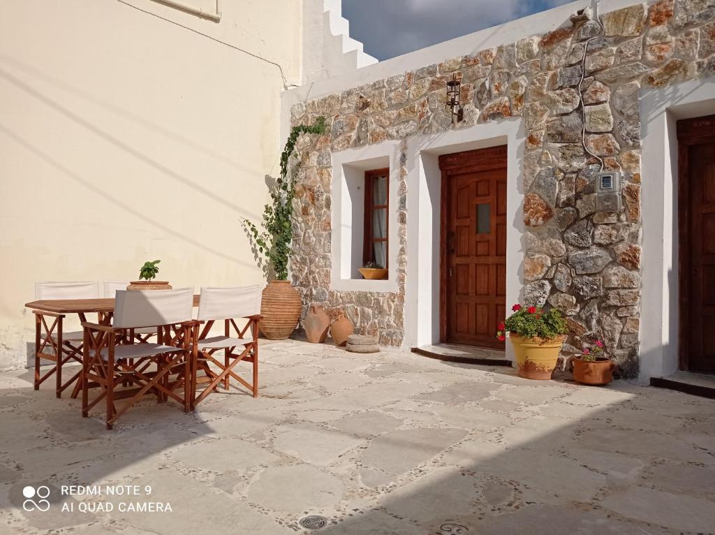 patio ze stołem i krzesłami przed budynkiem w obiekcie Anastasia's Home w mieście Émbonas