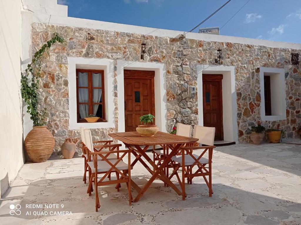 a wooden table and chairs in front of a building at Anastasia's Home in Émbonas