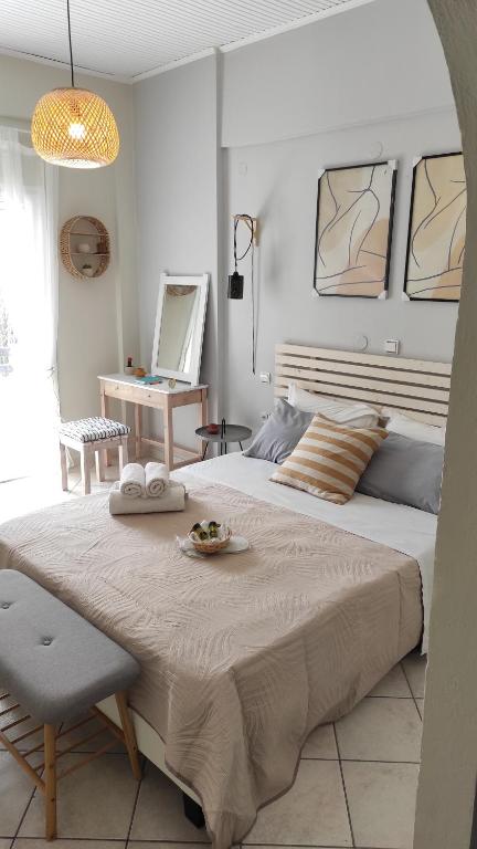 een slaapkamer met een groot bed met een tafel en een stoel bij Boho Studios Liapades - Near restaurants, bus and beaches in Liapades