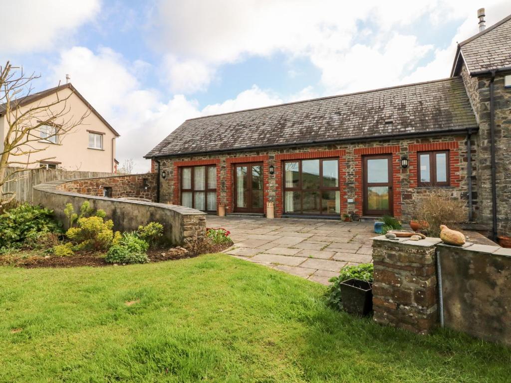 an external view of a stone house with a patio at Pound Cottage in Great Torrington