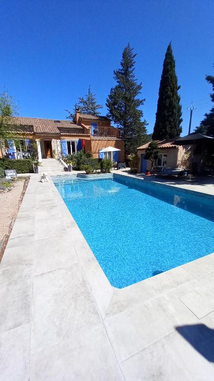 ein Pool vor einem Haus in der Unterkunft Les Jasmins de Salelles in Le Bosc