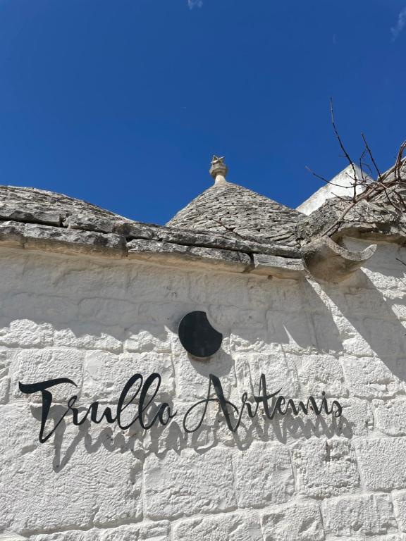 un bâtiment en briques blanches avec un chapeau dans l'établissement Trullo Artemis, à Alberobello
