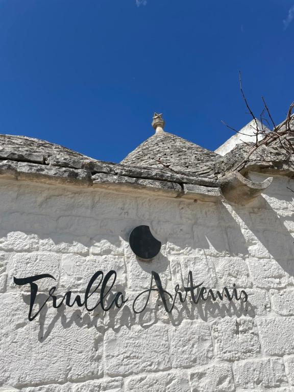 a white brick building with a hat on it at Trullo Artemis in Alberobello