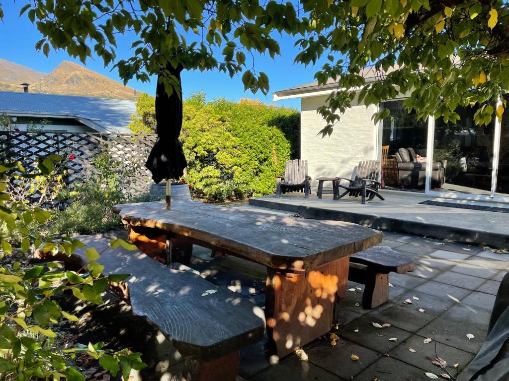 a picnic table and bench in front of a house at Cottage on Kent in Arrowtown