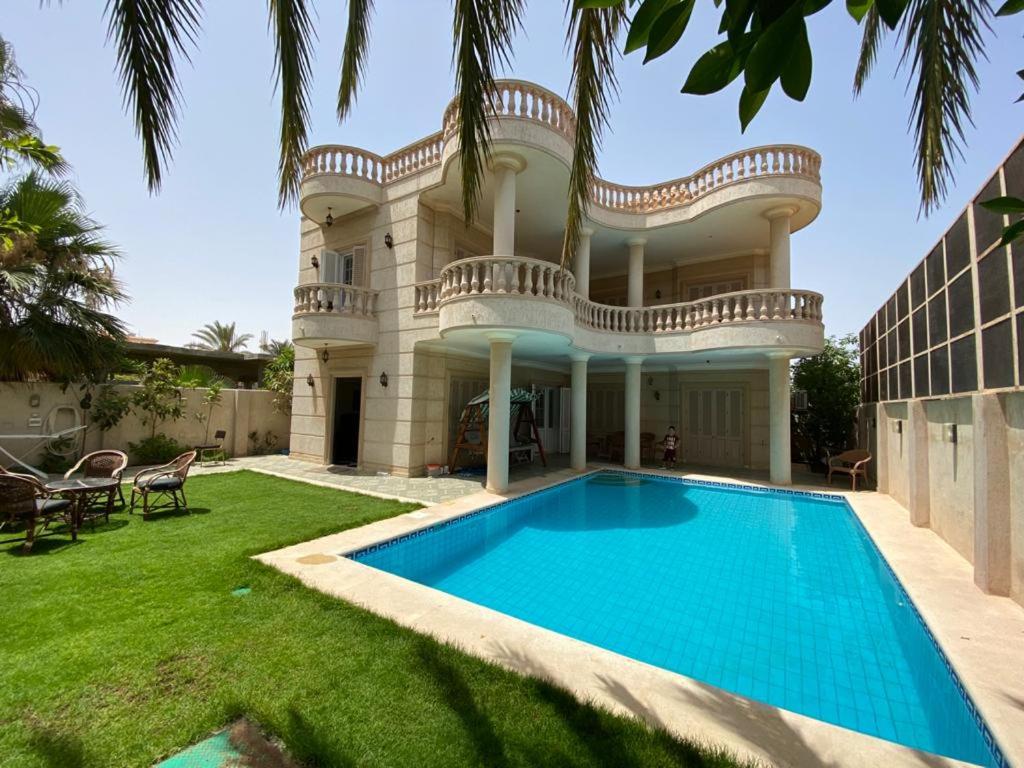 an exterior view of a house with a swimming pool at Paradise Villa - King Mariout in King Mariout