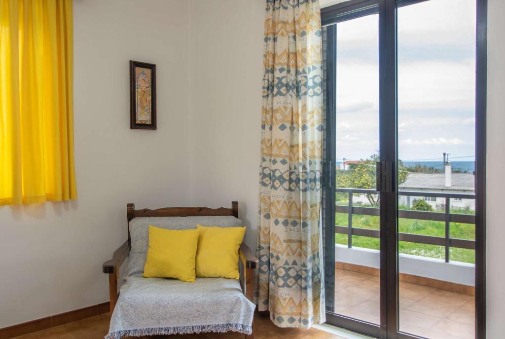 een kamer met een stoel en een raam met een balkon bij Kypseli Farmhouse in Kypseli