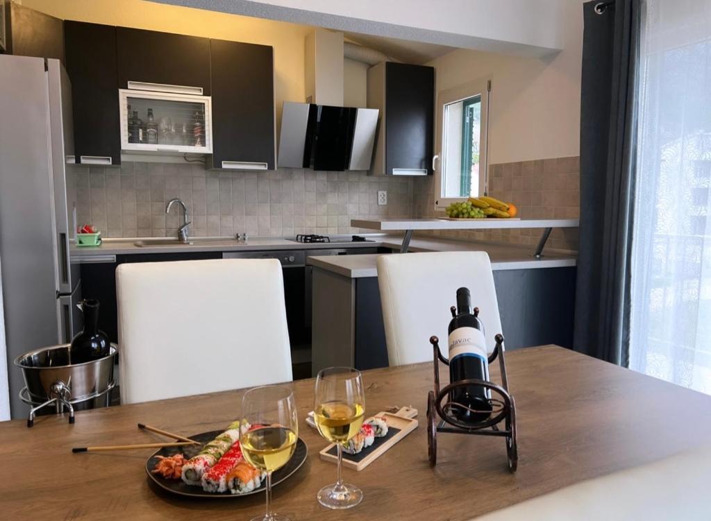 a kitchen with a table with a plate of food and wine glasses at Apartments Mihi in Podstrana