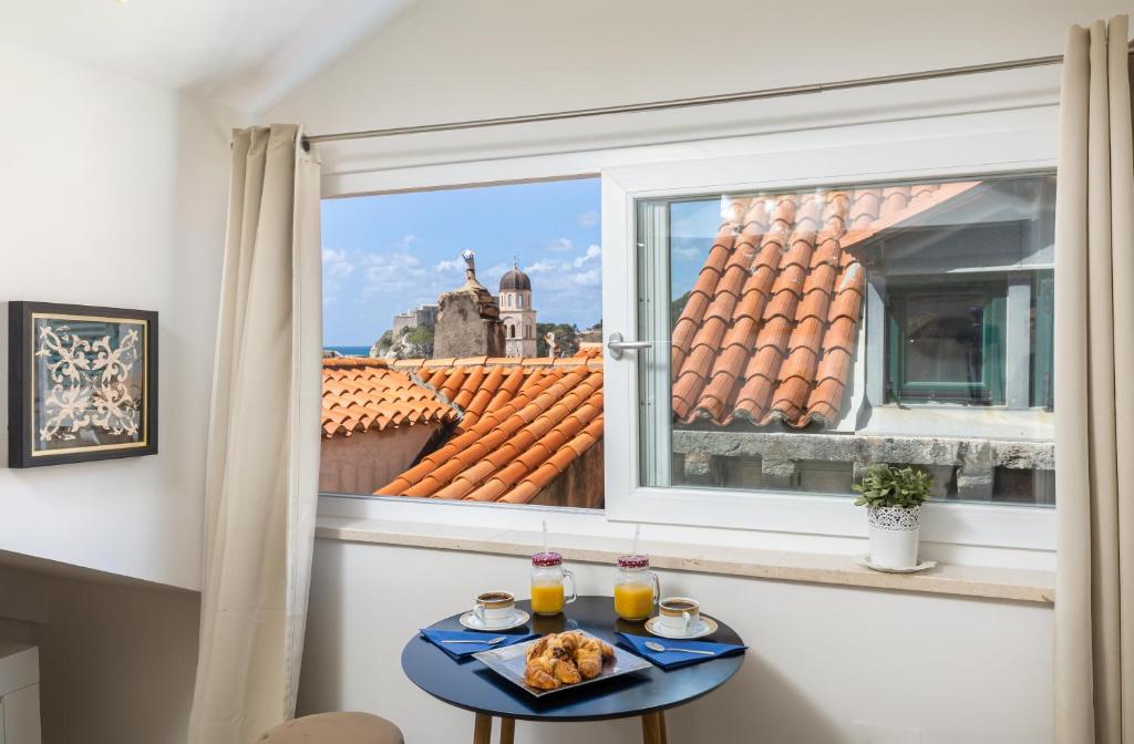 un tavolo con cibo sopra accanto a una finestra di Dubrovnik Old Town Apartments a Dubrovnik