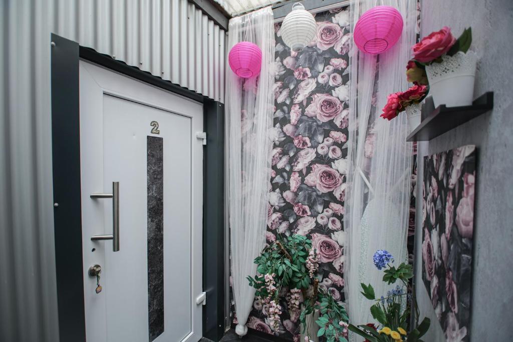 a door with pink lanterns and a wall with flowers at Modern mitten in der Stadt und doch sehr ruhig 2 Minuten zu Therme in Bad Ems