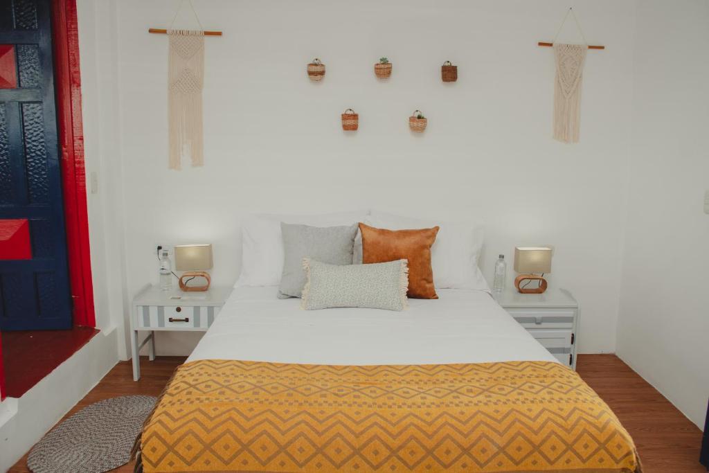 ein Schlafzimmer mit einem Bett und zwei Nachttischen in der Unterkunft Hacienda Boutique Santa Rosanna in Santa Rosa de Cabal