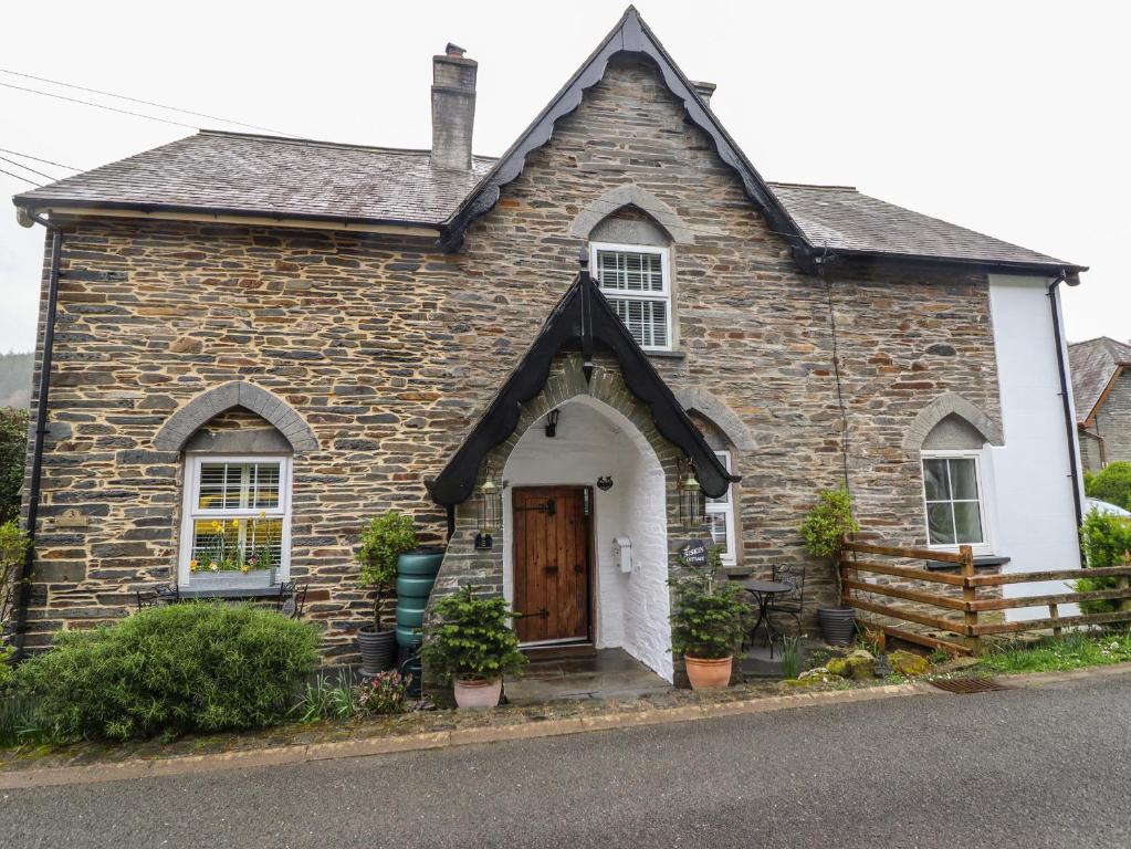 an old stone house with a wooden door at Siskin in Machynlleth