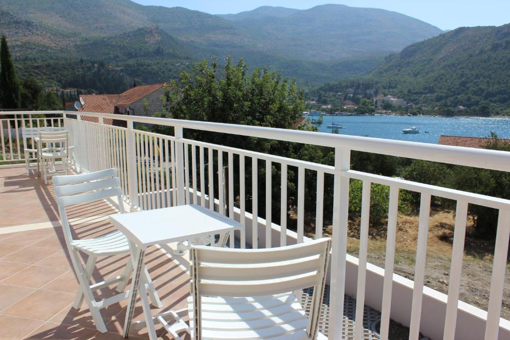 a balcony with chairs and a table and a view of the mountains at Apartments Villa Eva in Slano