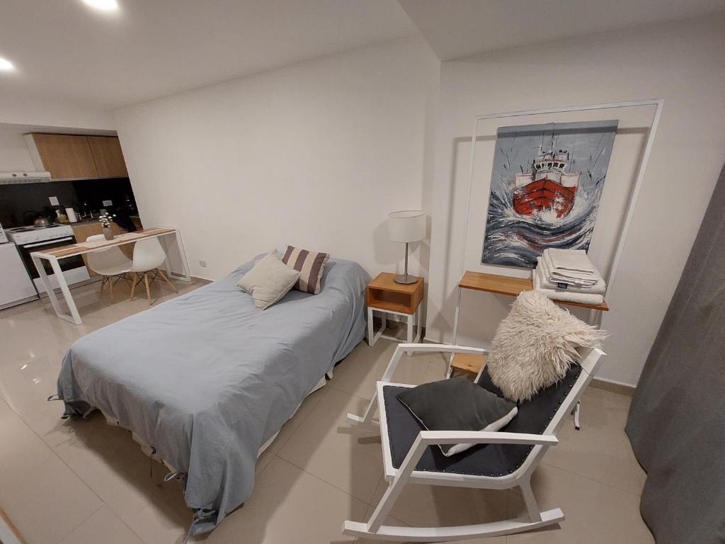 a bedroom with a bed and a desk and a chair at Oshowia in Ushuaia