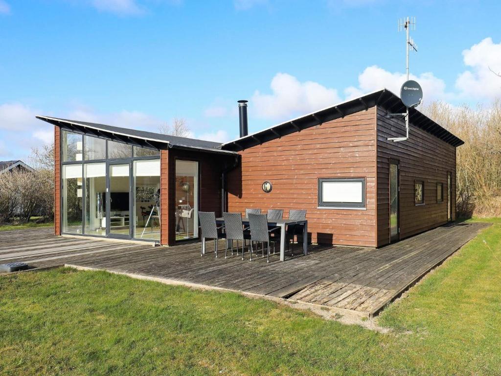 une maison dotée d'une terrasse en bois avec une table et des chaises dans l'établissement Holiday home Vestervig XXXII, à Vestervig