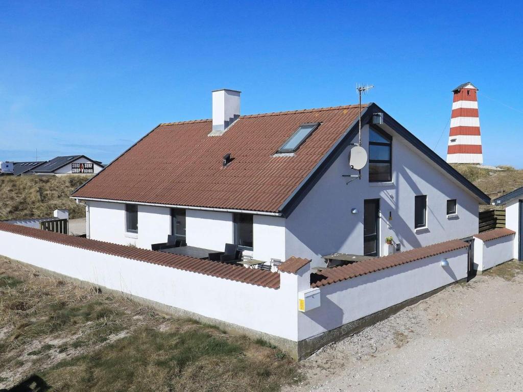 a house with a lighthouse on the beach at 10 person holiday home in Thisted in Nørre Vorupør