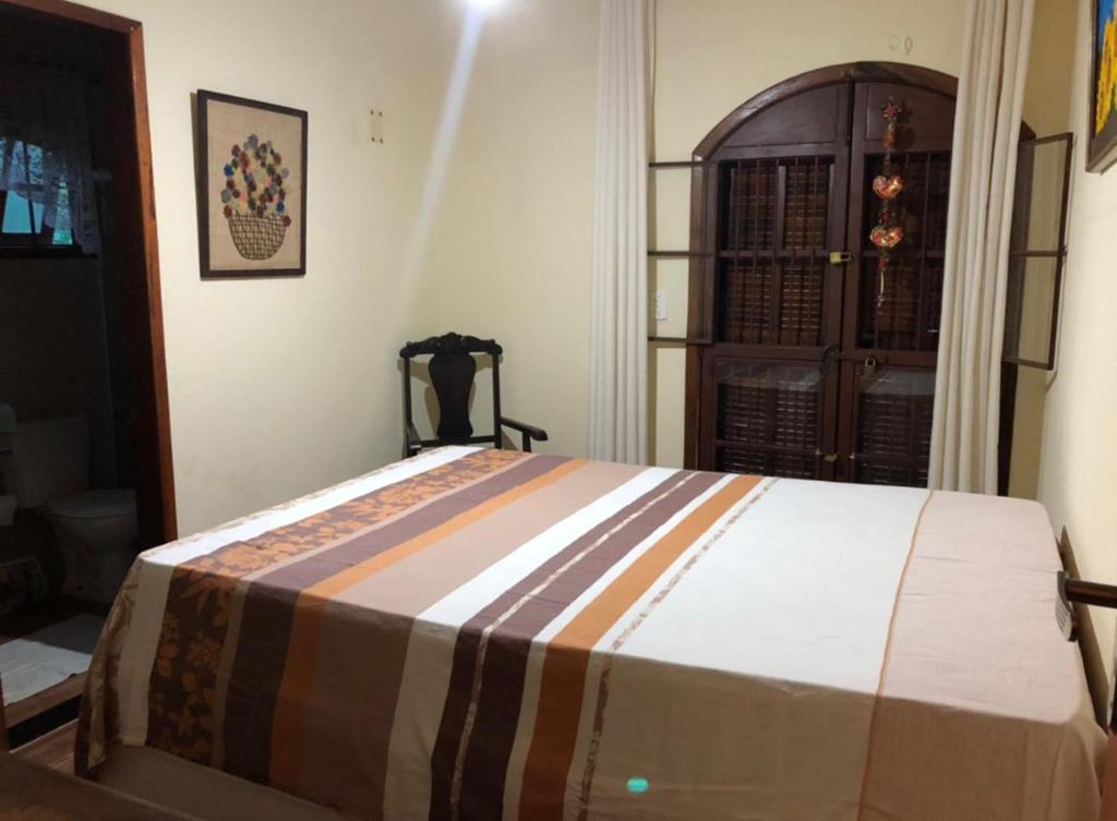 um quarto com uma cama grande num quarto em Casa de campo com piscina em Paty do alferes em Paty do Alferes