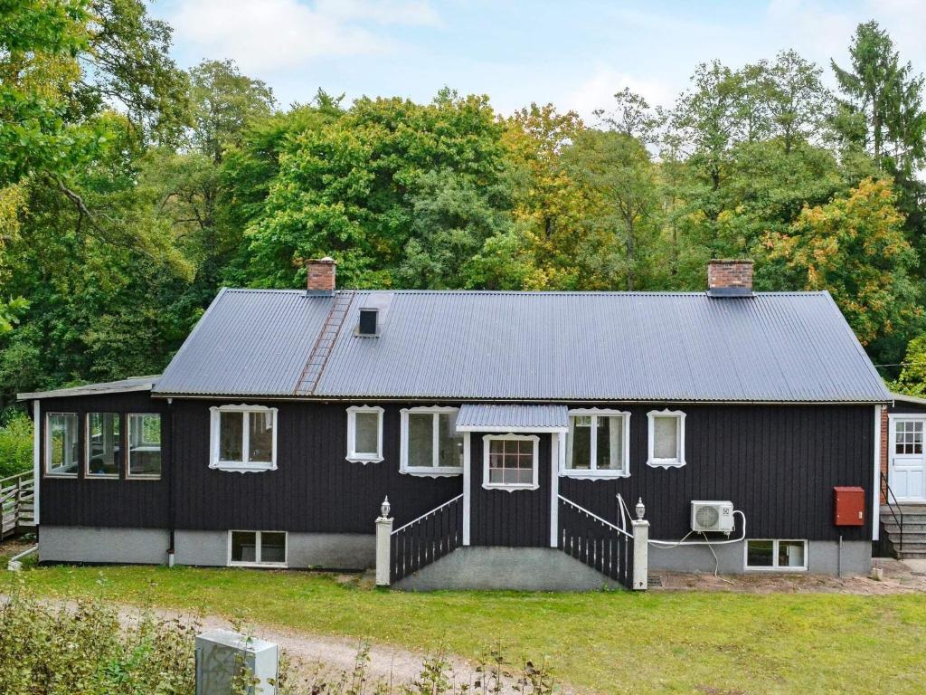 een zwart huis met een zwart dak bij Holiday home Vittsjö IV in Vittsjö