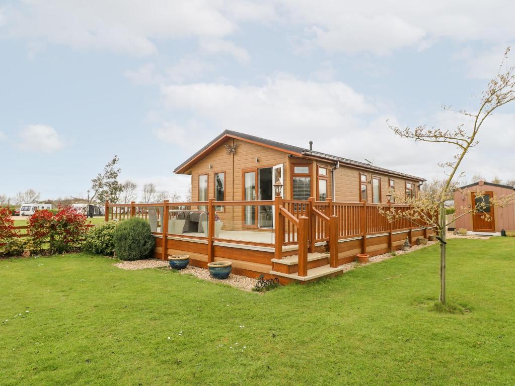 een huis met een groot terras in een tuin bij Lake View Lodge in Grantham