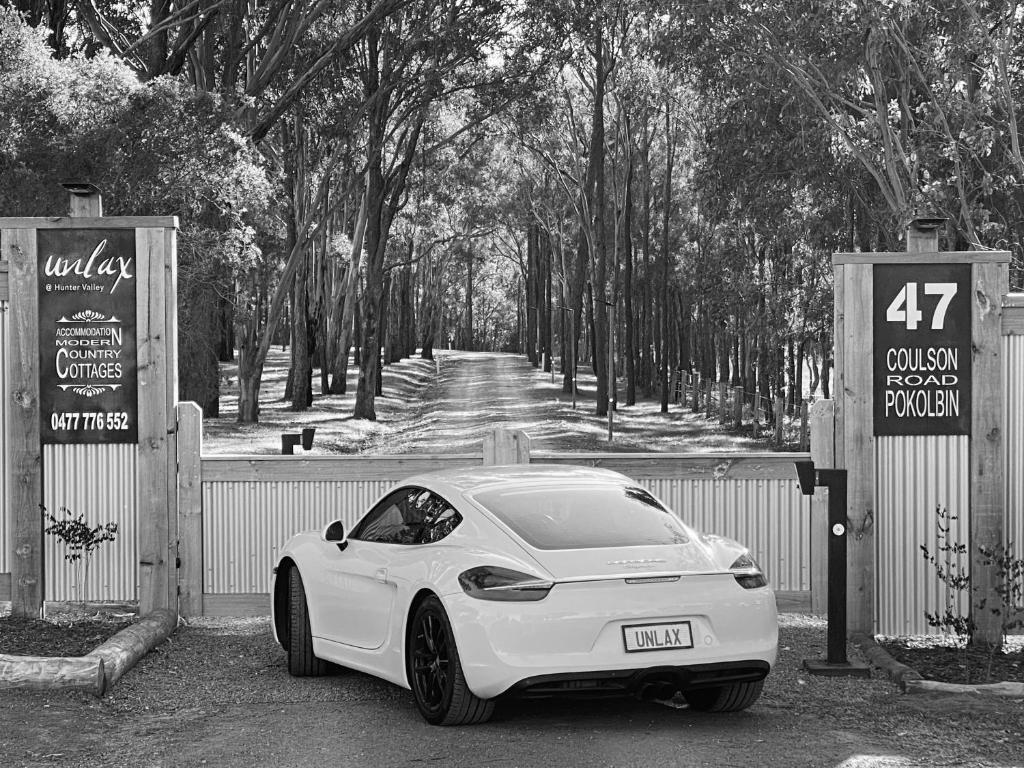 a white car parked in front of a fence at Unlax @ Hunter Valley in Pokolbin
