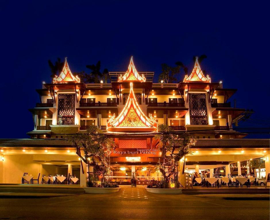 a large building with lights on it at night at Rayaburi Hotel, Patong in Patong Beach