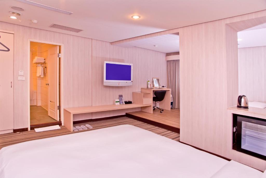 a hotel room with a bed and a television at Yomi Hotel - ShuangLian MRT in Taipei