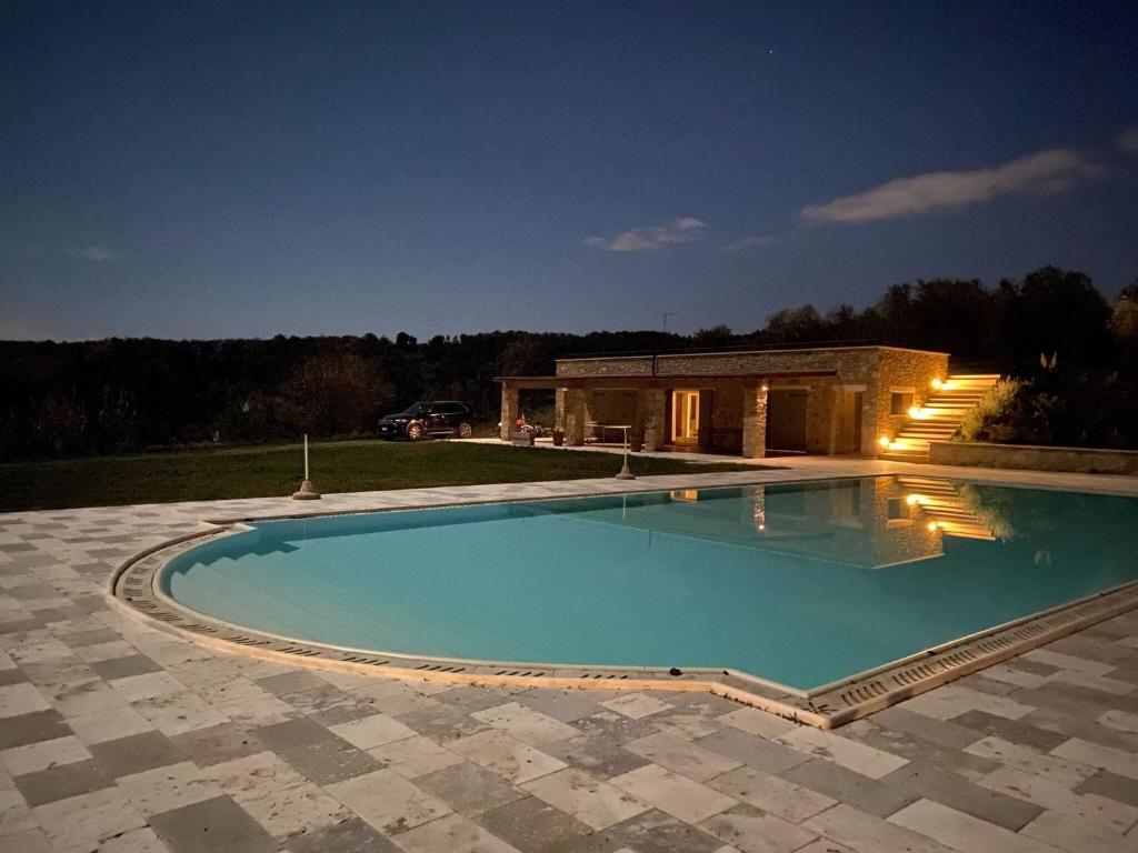a large swimming pool in front of a house at Belvilla by OYO Podere San Giovanni ventisei in Chianni